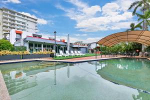 a swimming pool in front of a building at Vitina Studio Motel in Darwin