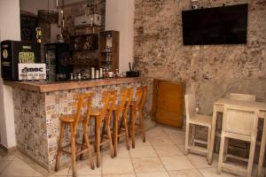 a bar with a row of wooden chairs at a counter at Casa Zahri Boutique Hostel in Cartagena de Indias