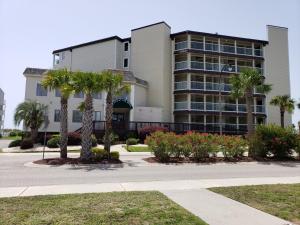 a building with palm trees in front of a street at A Place at the Beach 406 in Myrtle Beach