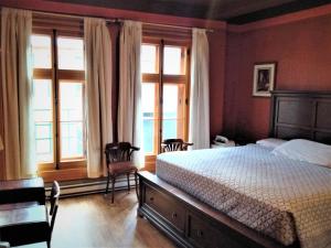 um quarto com uma cama e duas janelas em L'intendant em Cidade de Quebec