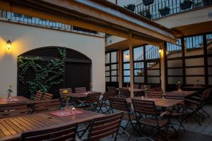 a patio with wooden tables and chairs in a building at Pension U Lilie in Prague