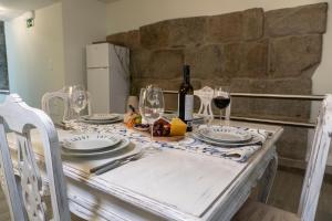 a white table with glasses and wine bottles on it at Ocean - Casa Sao Joao - 4 Star Tourist Apartments in Angra do Heroísmo