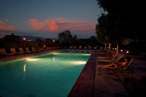 a woman laying in a chair next to a swimming pool at Hotel Albuquerque At Old Town in Albuquerque