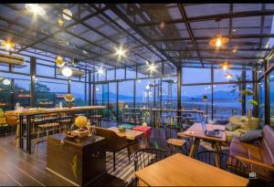 un restaurante con mesas y sillas y vistas al océano en Kaengkrachan Boathouse Paradise Resort, en Kaeng Kachan