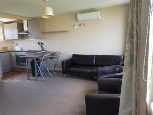 sala de estar con sofá y mesa en Camber Sands Holiday Chalets - The Grey, en Camber