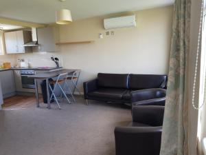 a living room with a couch and a table at Camber Sands Holiday Chalets - The Grey in Camber