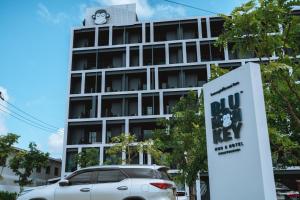 Blu Monkey Hub and Hotel Chanthaburi في تشانتابوري: سيارة بيضاء متوقفة أمام مبنى