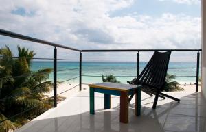 d'une chaise et d'une table sur un balcon donnant sur la plage. dans l'établissement Kay Hotel, à Playa del Carmen