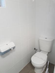 a white toilet sitting next to a white sink at Main Street Motel in Hervey Bay