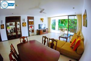 a living room with a couch and a table at Casuarina Shores Apartment - SHA Plus in Bang Tao Beach