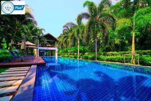 una piscina en un complejo con palmeras en Casuarina Shores Apartment - SHA Plus en Bang Tao Beach