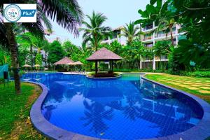 a swimming pool with a gazebo next to a building at Casuarina Shores Apartment - SHA Plus in Bang Tao Beach