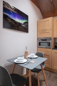 a kitchen with a table and chairs and a tv at Contemporary One Bedroom Apartment Close To All Amenities In Conservation Area in Tain