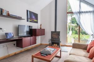 a living room with a fireplace and a tv at Contemporary One Bedroom Apartment Close To All Amenities In Conservation Area in Tain