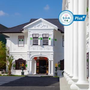 a white house with columns and a sign that reads sta plus at Sound Gallery House - SHA Plus in Phuket