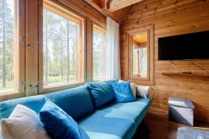 a living room with a blue couch and a television at Viihtyisä lomamökki Levillä in Sirkka