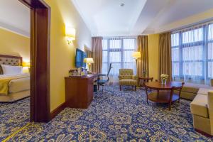 une chambre d'hôtel avec un lit et un salon dans l'établissement Ramada by Wyndham Almaty, à Almaty