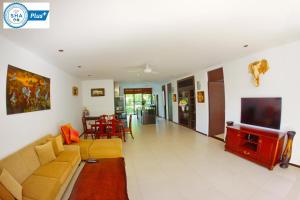 a living room with a couch and a tv at Casuarina Shores Apartment - SHA Plus in Bang Tao Beach