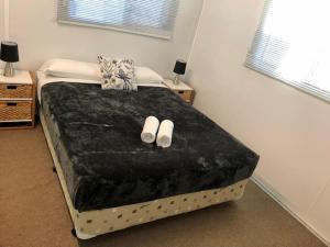 Un dormitorio con una cama con zapatos blancos. en Bundaberg East Cabin and Tourist Park, en Bundaberg