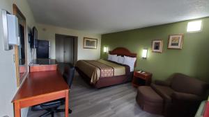 a hotel room with a bed and a desk at Big Spring Inn Madisonville in Madisonville