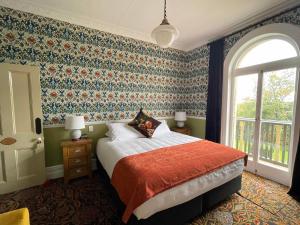 um quarto com uma cama com papel de parede floral em Casa Nova House em Oamaru