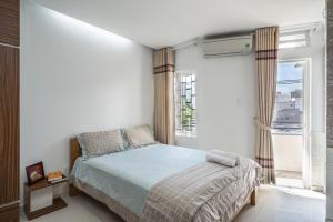 a bedroom with a bed and a large window at Green Cocoon in Ho Chi Minh City