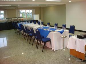 una sala de conferencias con una mesa larga y sillas azules en Gelps Hotel, en Rio Verde