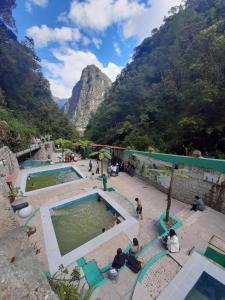a group of people sitting around a swimming pool in a mountain at Machupicchu Lodging in Machu Picchu
