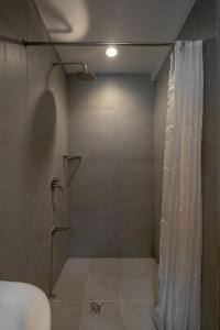 y baño con ducha y cortina de ducha. en iHotel Uptown BGC en Manila