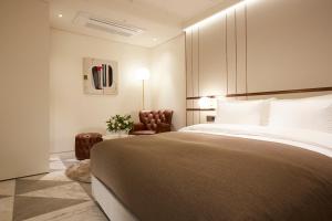 a bedroom with a large bed and a chair at 9 Brick Hotel in Seoul