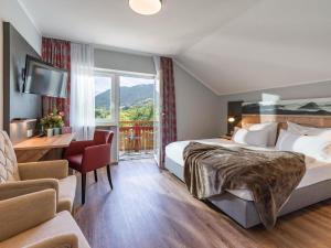 ein Hotelzimmer mit einem Bett und einem großen Fenster in der Unterkunft Das Johannesbad - DAS MEDICAL SPA & VITAL REFUGIUM in Bad Kohlgrub
