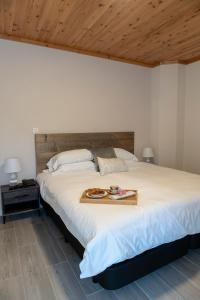 a bedroom with a large bed with a tray on it at Garden - Casa Sao Joao - 4 Star Tourist Apartments in Angra do Heroísmo