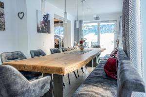 a dining room with a wooden table and chairs at Au Villa in Söll