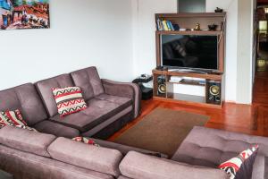a living room with a couch and a tv at Inka City Hostel in Cusco