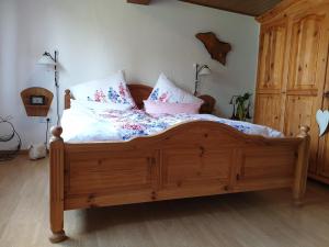 een slaapkamer met een houten bed met kussens erop bij Ferienwohnung zur Töpferstube in Spabrücken