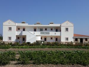 una grande casa bianca con molte finestre di VENOS APARTMENTS a Marmári