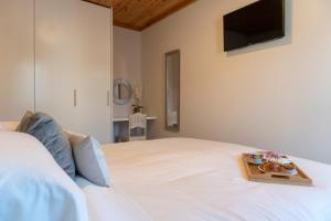 ein Schlafzimmer mit einem weißen Bett und einem Tablett mit Essen darauf in der Unterkunft Garden - Casa Sao Joao - 4 Star Tourist Apartments in Angra do Heroísmo