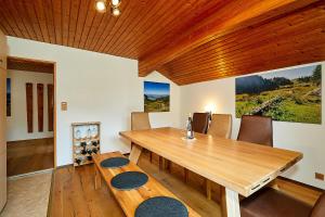 een eetkamer met een houten tafel en stoelen bij Chiemgauferienwohnungen - Stierschneiderhof in Unterwössen