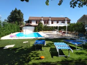 un cortile con piscina, sedie e una casa di Corte Bussari ad Arquà Polesine