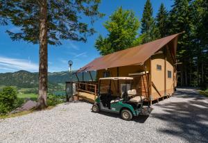 un carro de golf estacionado frente a una casita en Ferienpark Terrassencamping Süd-See, en Walchsee