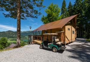 a golf cart parked in front of a tiny house at Ferienpark Terrassencamping Süd-See in Walchsee