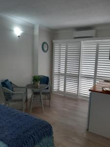 1 dormitorio con cama, mesa y reloj en SeaTurtle, en Clifton Beach