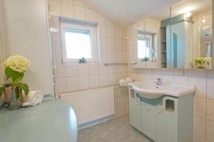 La salle de bains est pourvue d'un lavabo et d'un miroir. dans l'établissement Appartement Unterweger, à Sankt Niklas an der Drau