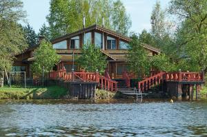 a large wooden house with a bridge over a body of water at Recreational resort Zavidovo in Zavidovo