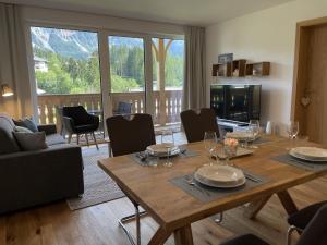 salon z drewnianym stołem i krzesłami w obiekcie Grimmingblick Apartment 206 by AA Holiday Homes w mieście Tauplitz