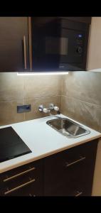 a kitchen with a sink and a microwave at Wellapartman Zamárdi in Zamárdi +46 photos