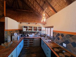 a large kitchen with blue cabinets and a counter top at Bona Kgole Private Game Lodge, Mabalingwe in Warmbaths
