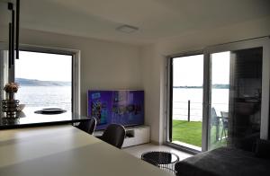 a living room with two large windows and a television at Beach apartment Paklenica-Deluxe in Seline