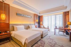 a hotel room with two beds and a desk at Pullman Foshan Shunde in Shunde