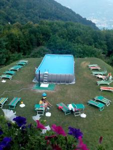 una persona sentada en una silla junto a una piscina en Hotel Ristorante La Sorgente en Plesio